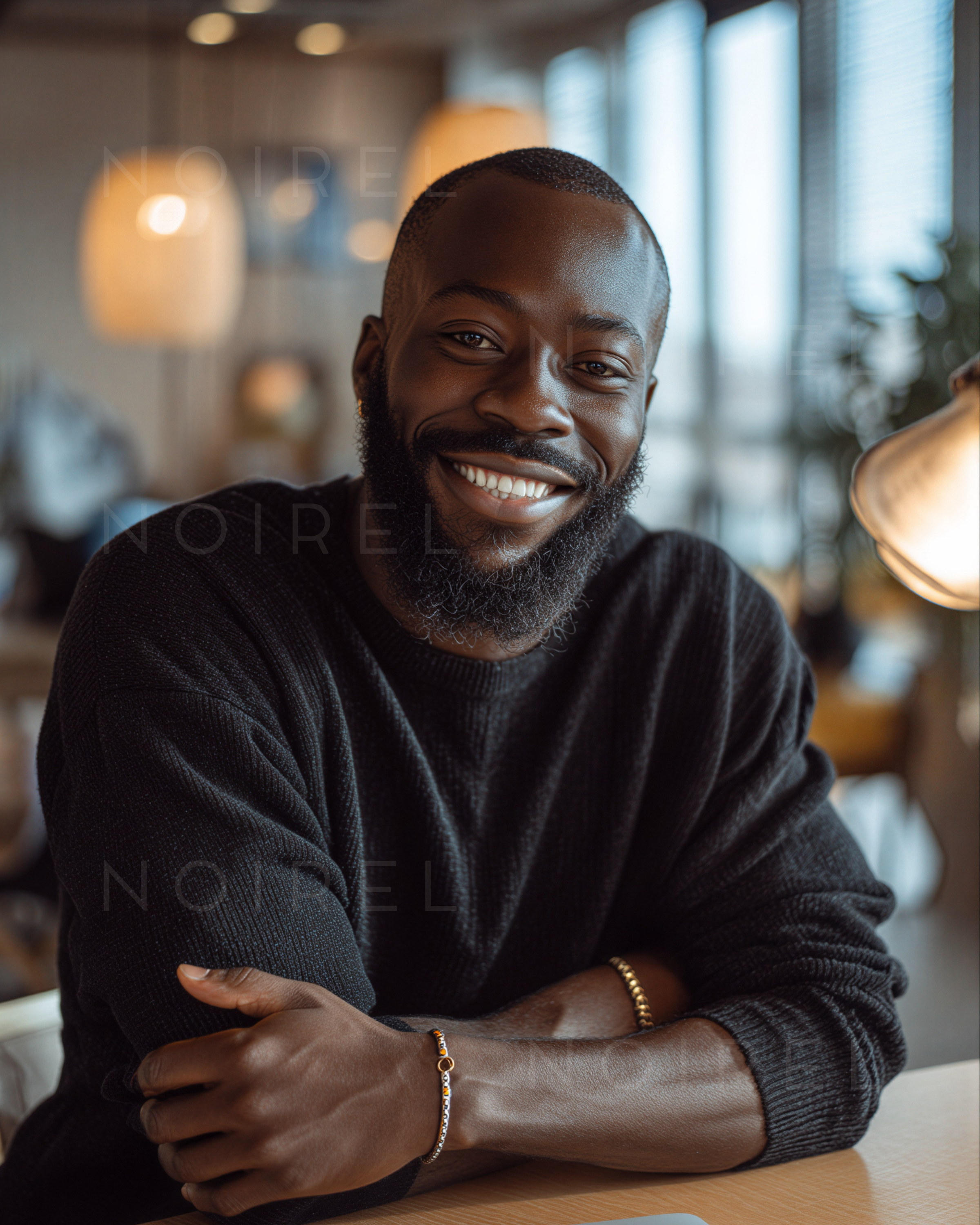 Dark knit turtleneck sweater, close-up of man smiling while leaning on table