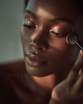 Make-up applicator brush applying foundation beside cheek