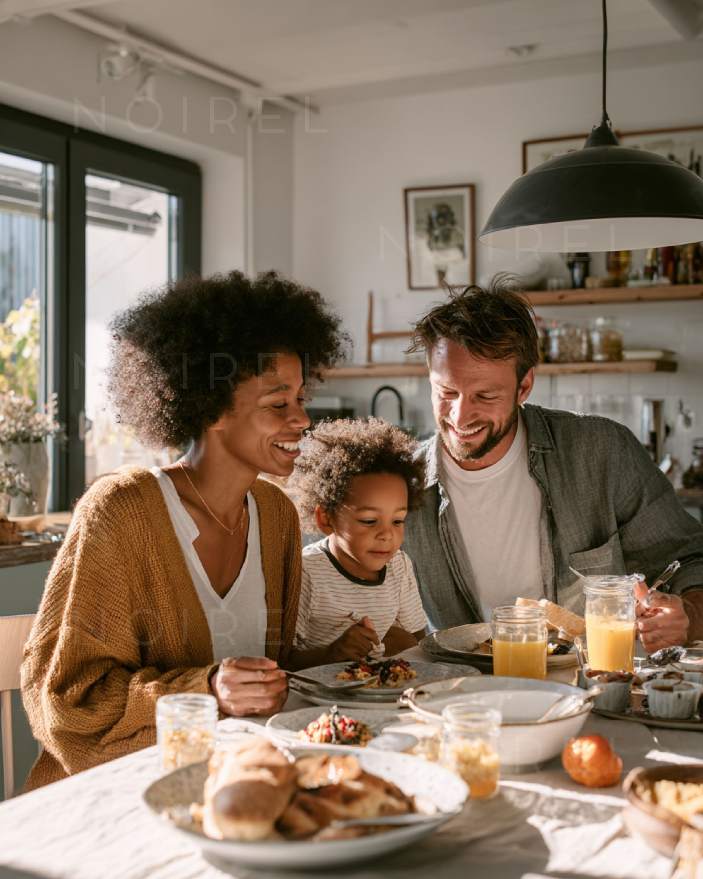 Family meal scene: adults and child smiling at a dining table in a kitchen
