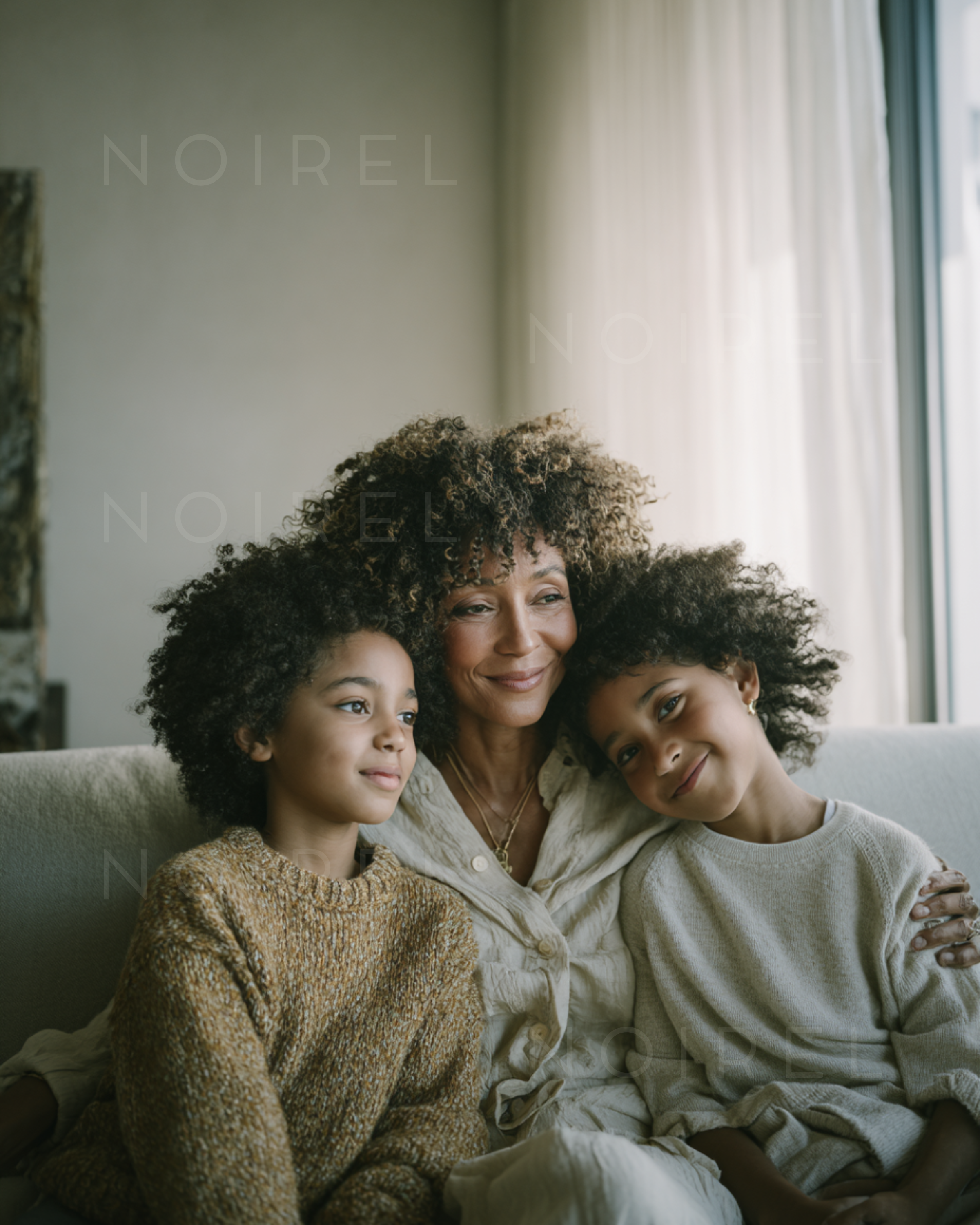 NOIREL family portrait: woman with two children seated on a sofa