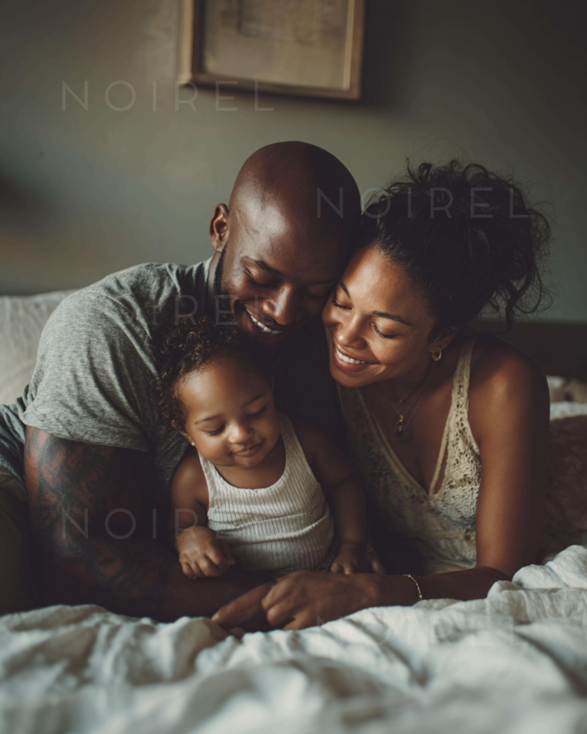 NOIREL NRL221: Family on a bed, parents cuddling the baby