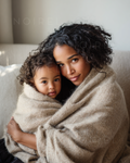 Beige knit wrap/shawl draped around a woman holding a baby