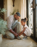 NOIREL NRL234 checkered shirt and light trousers, kneeling beside a child