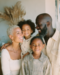 Smiling family of four in light casual outfits