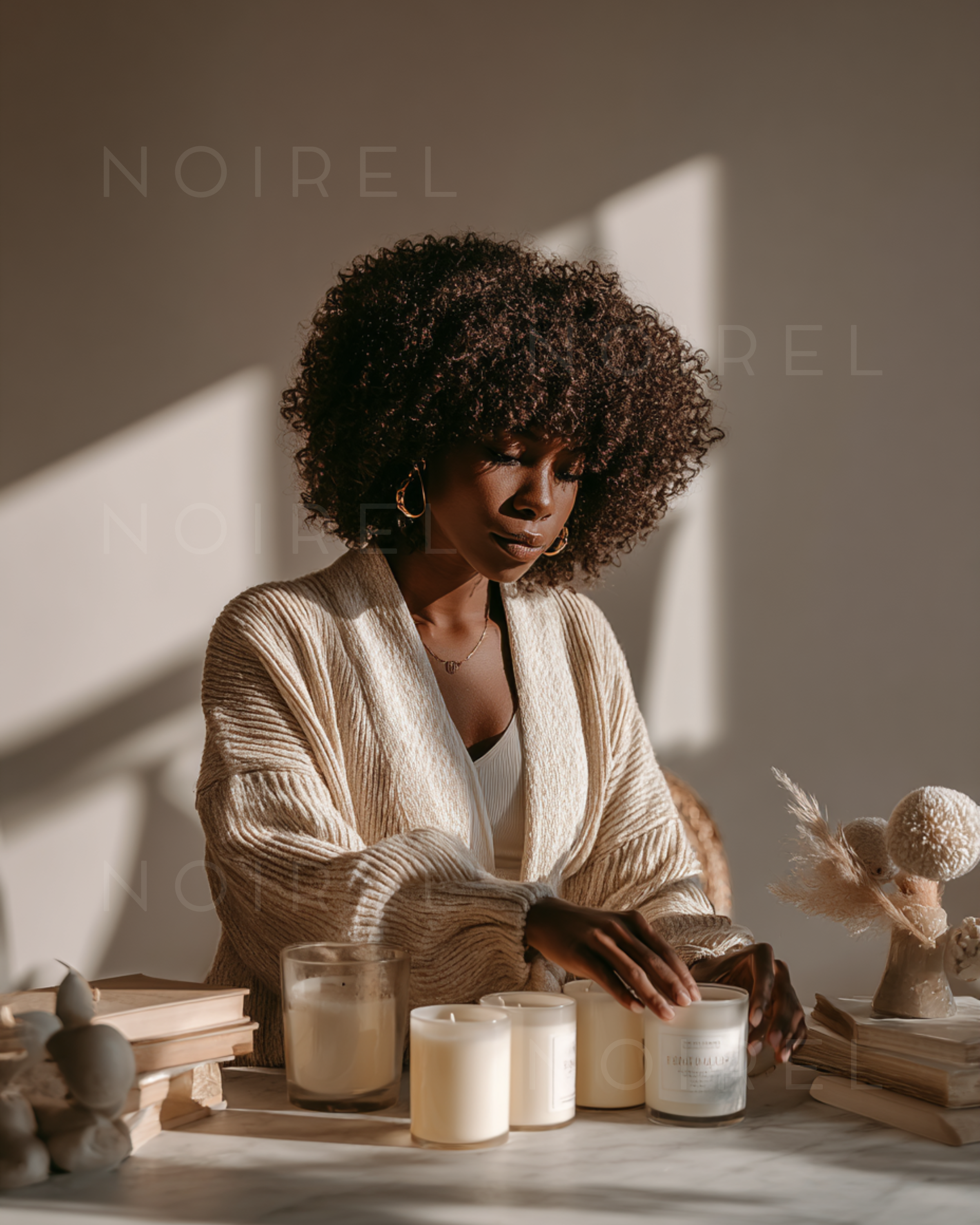 Cream knit cardigan over white top, model with curly hair, hands on table
