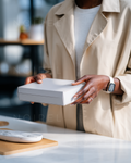 Beige shirt and hands holding a rectangular gray gift box