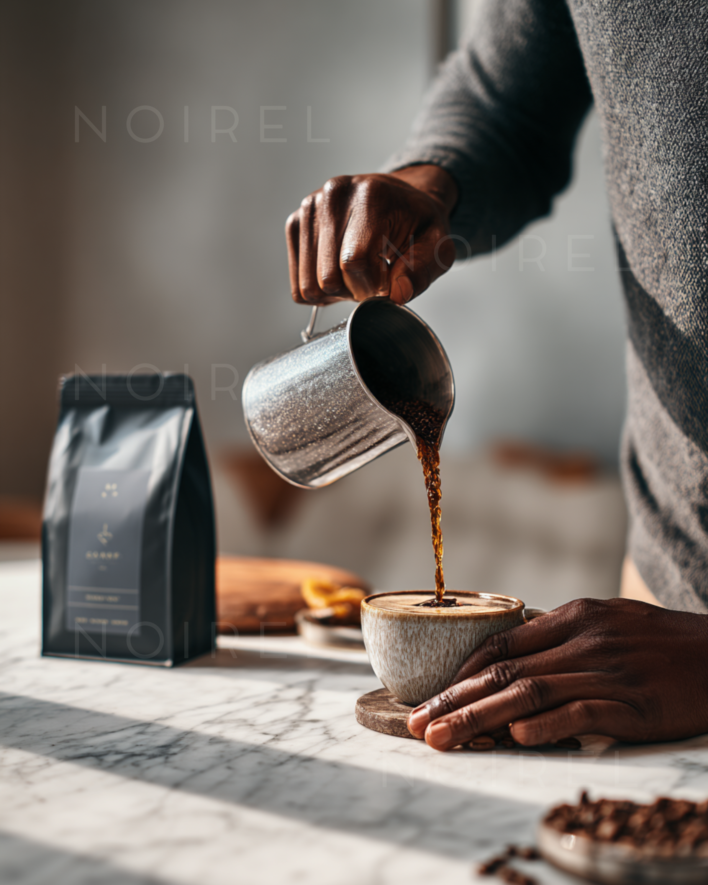 Metal kettle pouring dark coffee into a cup, hands holding a ceramic mug