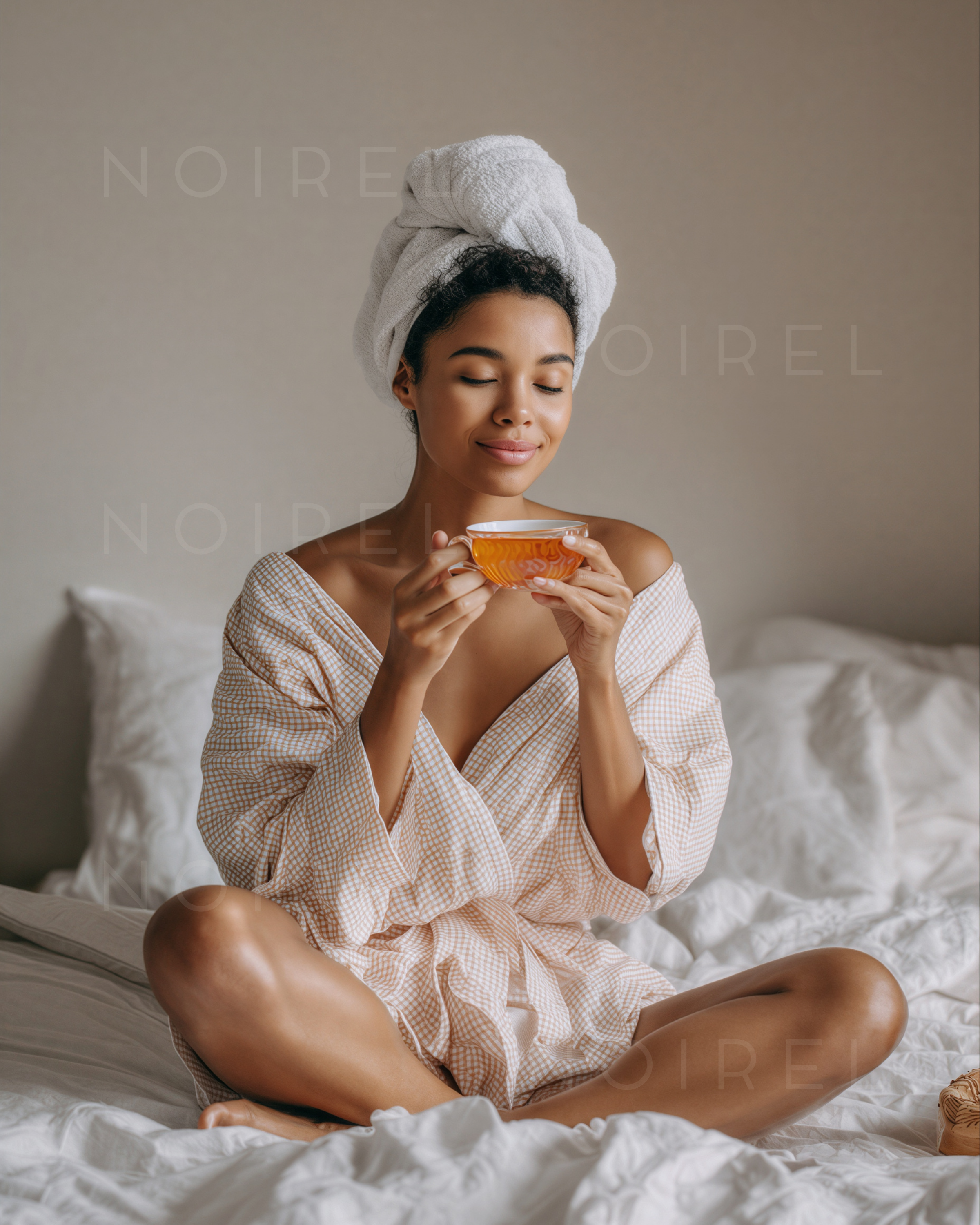 Weiße Bade-/Wellnessrobe mit Gürtel und weißem Kopfhandtuch, hält Tee im Becher