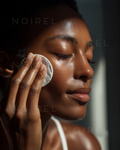 NOIREL facial skincare application—hand applying cream to cheek and forehead