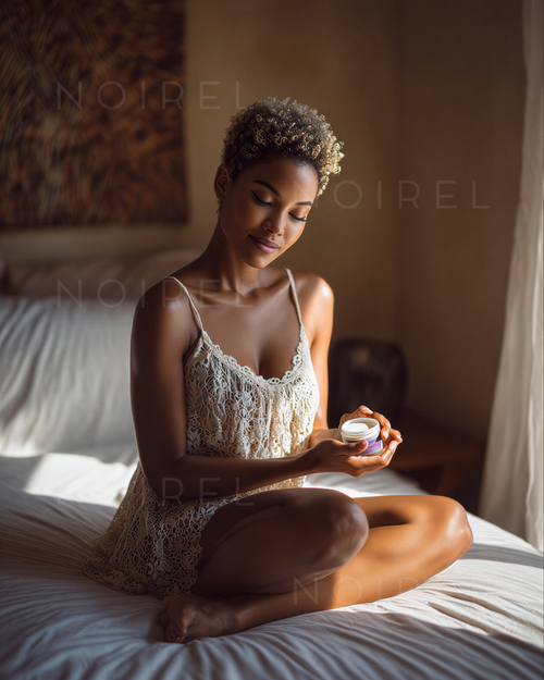 Small round skincare cream jar held in hand